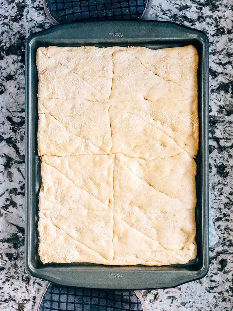 Baked light, fluffy and golden brown crescent roll crust for vegetable pizza.