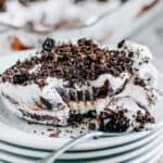 Plated Oreo Dirt Dessert with layers of delightful whipped cream cheese, Oreo crumb crust, and chocolate pudding.