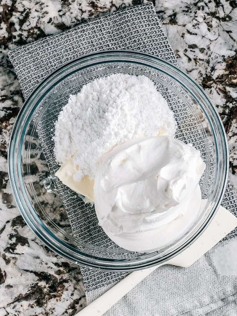 Softened cream cheese, cool whip, and powdered sugar in a mixing bowl