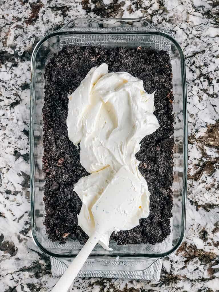 The cream cheese and whip topping layer spread evenly over the Oreo crumb crust.