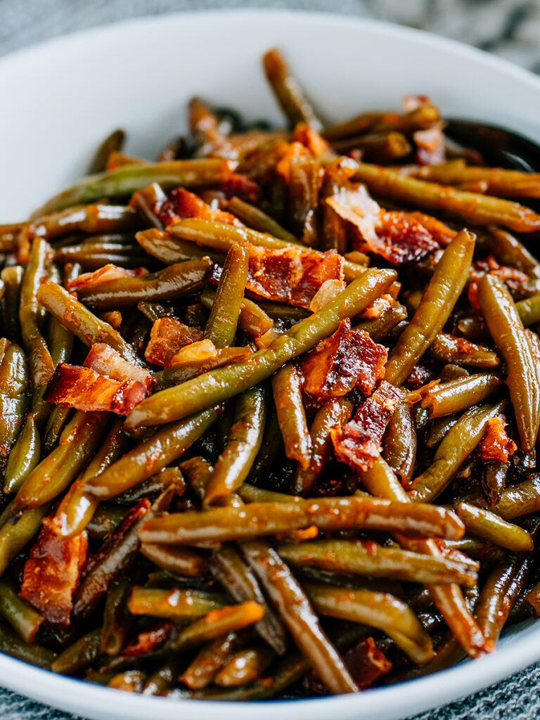 Delicious tangy and tasty BBQ Green Beans in a white round serving dish.