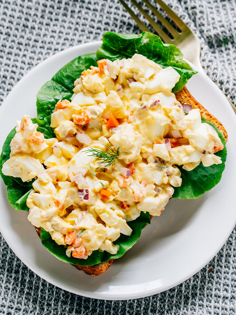 Egg salad on buttered wheat toast and garden lettuce.