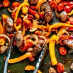 Browned Italian sausage and tender vegetables on a sheet pan in a homemade marinade.