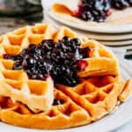 Blueberry compote on top of waffles.