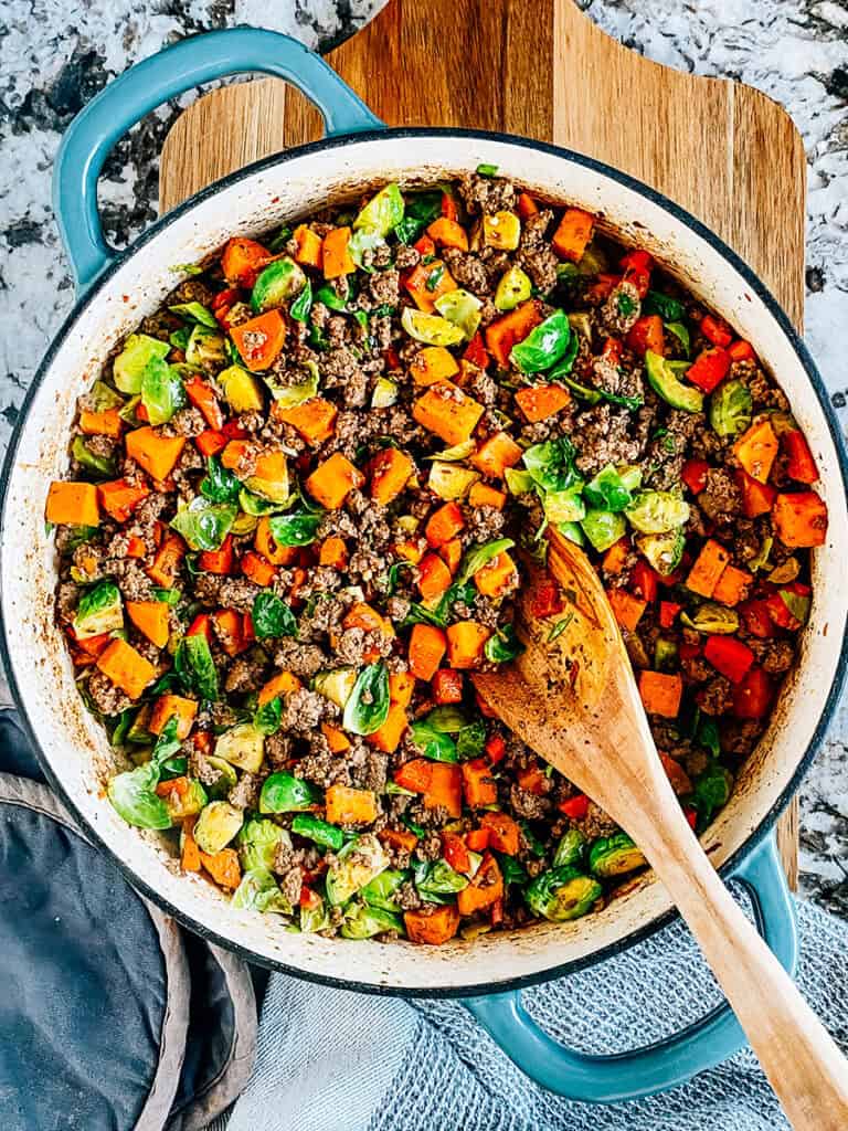 Perfectly seasoned ground beef with sautéed diced sweet potatoes, carrots, and Brussels sprouts in a large skillet! The perfect family meal!