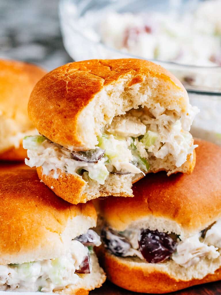 A bite taken out of this amazing chicken salad sandwich.