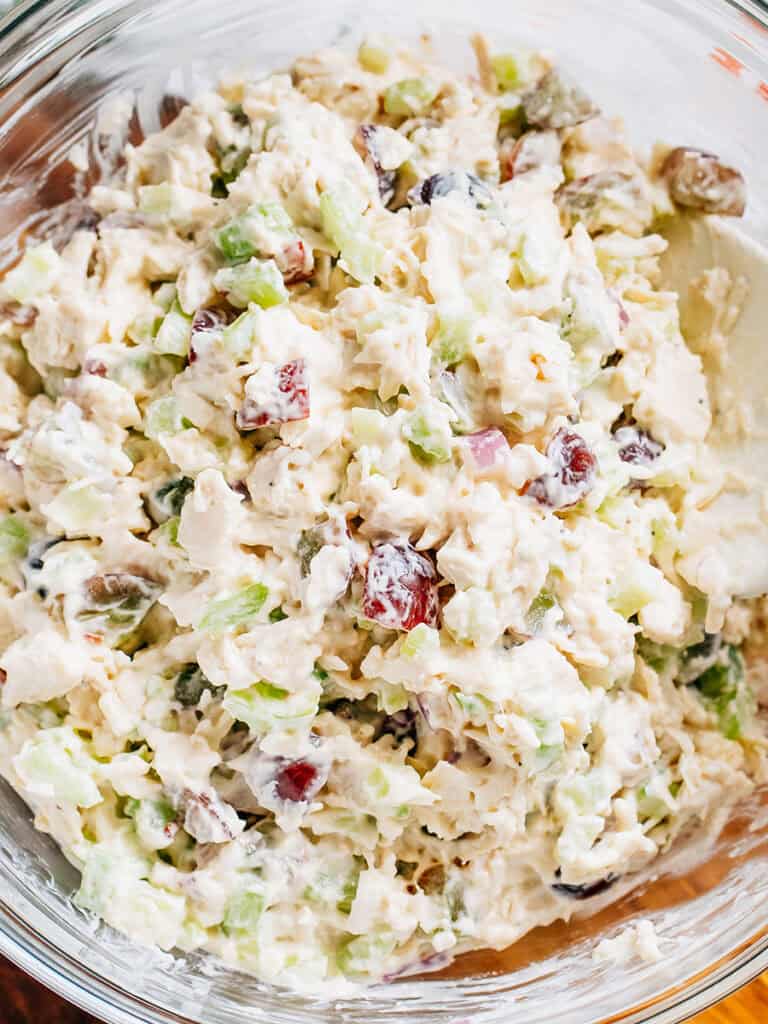 Complete easy chicken salad dish with a creamy dressing covering cooked chicken, red grapes, celery, and red onion.