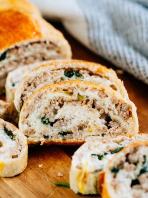A slice of sausage bread showing of delicious sausage, cheese, and spinach in a bread loaf.