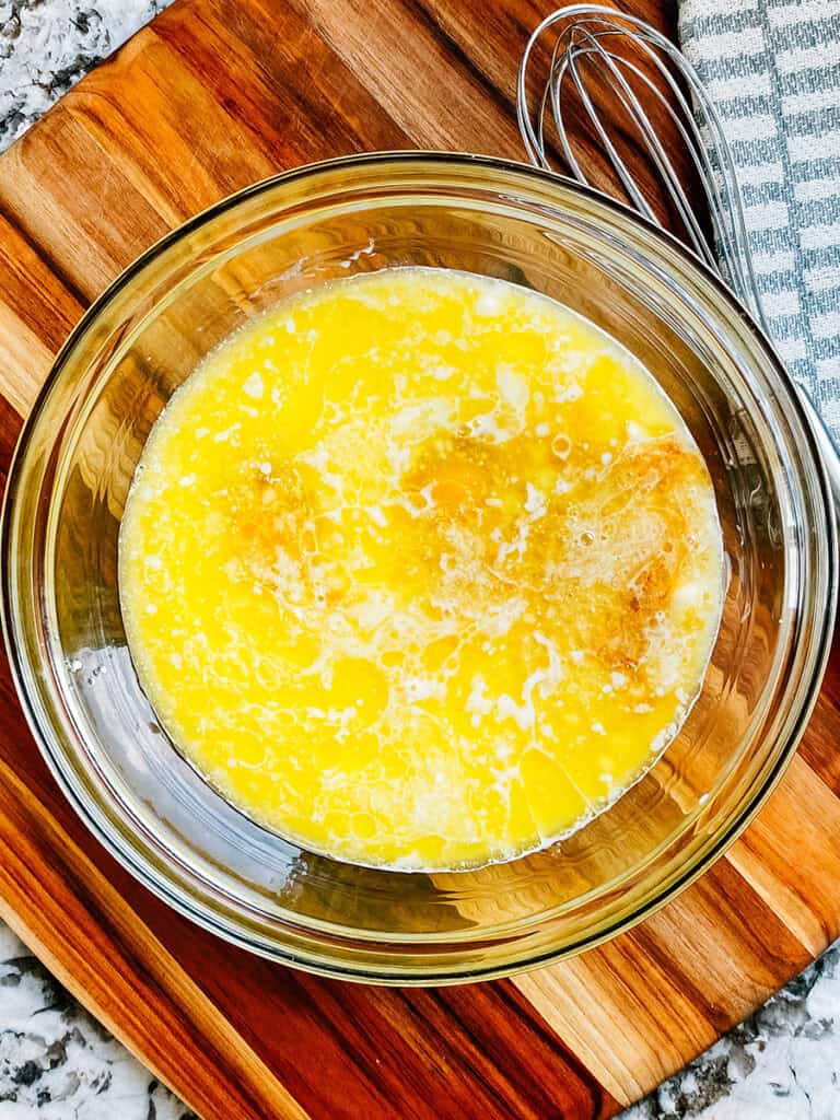 Milk, eggs, melted butter, pure maple syrup, brown sugar, and vanilla in a large glass mixing bowl.