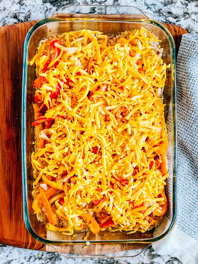 Shredded cheese on top of the baked chicken and veggies.