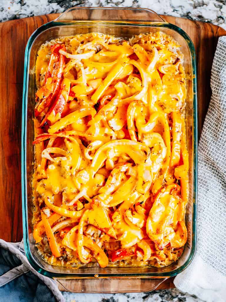Melted cheese on top of fajita seasoned bake chicken and vegetables.
