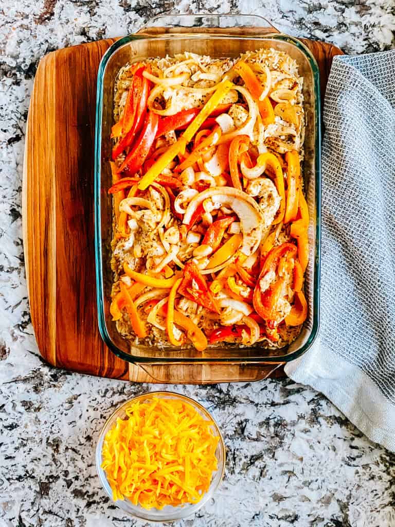 A 9x13in dish with baked chicken fajitas and cheese on the side.