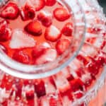 Frozen strawberries floating on top of this strawberry lemonade. The perfect punch for a Galentine's Day celebration!