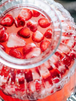 Frozen strawberries floating on top of this strawberry lemonade. The perfect punch for a Galentine's Day celebration!