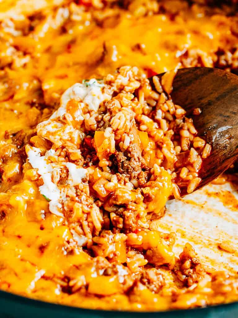 A scoop of delicious taco meat, cheese and rice. This beef skillet if perfect for burritos, bowls, and as a taco filling!
