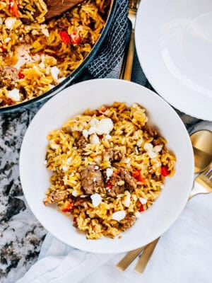 A bowl of sausage and zucchini orzo bake with corn and cheese. It's a delicious one-pot meal deal!