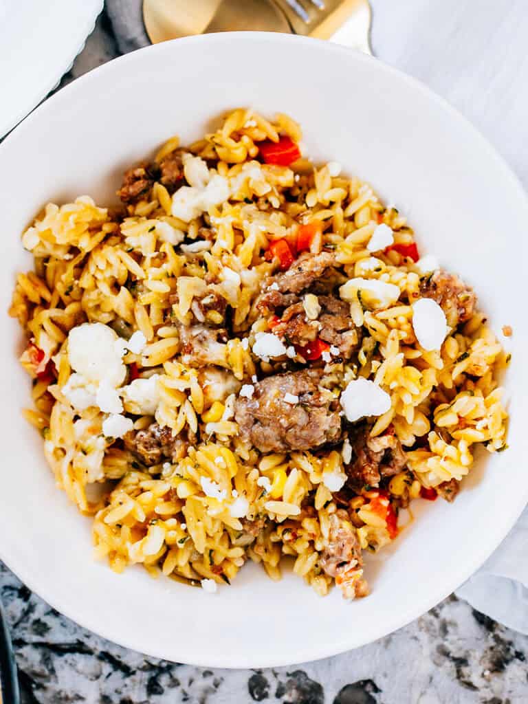 Close of a bowl of this orzo bake with tender Italian sausage, shredded zucchini, peppers, onions, and flavor!