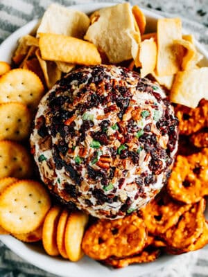 Delicious and easy this is a festive Cranberry Pecan Cheese Ball is surrounded by our favorite crackers and pretzels.