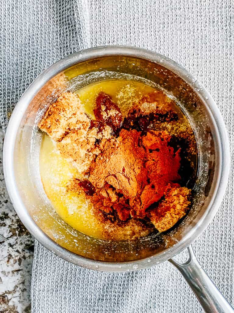 Cinnamon, brown sugar, and vanilla extract added to the melted butter in the saucepan.
