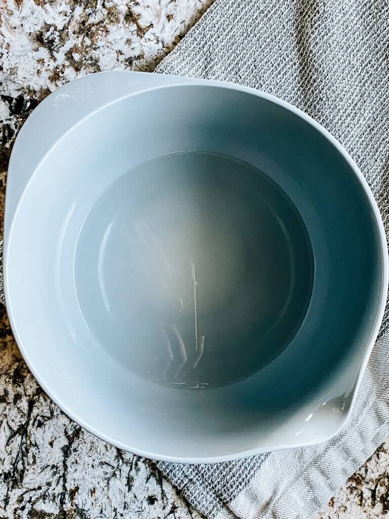 Warm water and sugar in a large bowl.