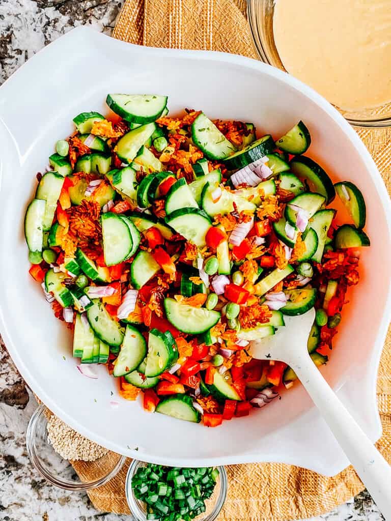 The salad ingredients mixed in a large bowl ready for the dressing and toppings.