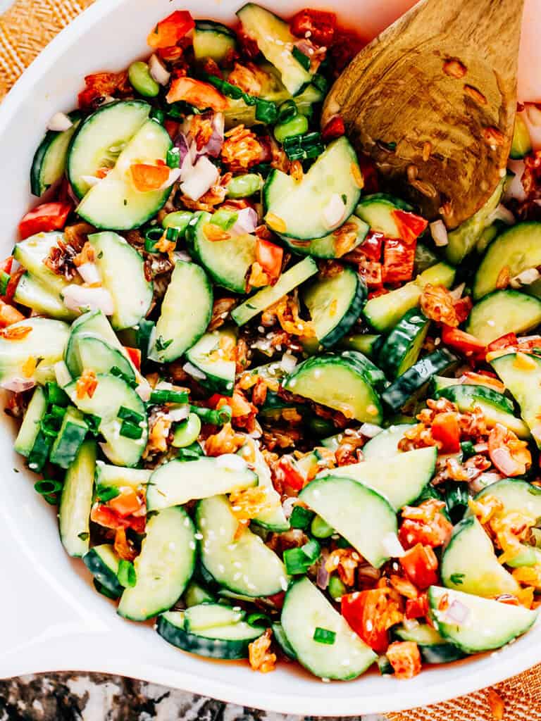 Serving bowl showing of the textures and colors of the salad made of crispy rice and cucumbers.