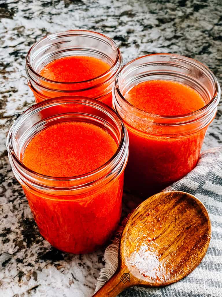 This easy strawberry jam poured into pint jars.