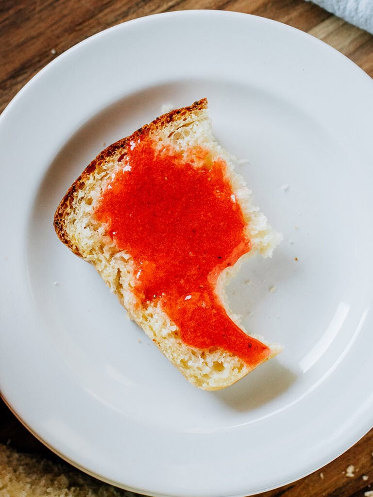 A half piece of the best strawberry jelly bread with a bite taken out of it.