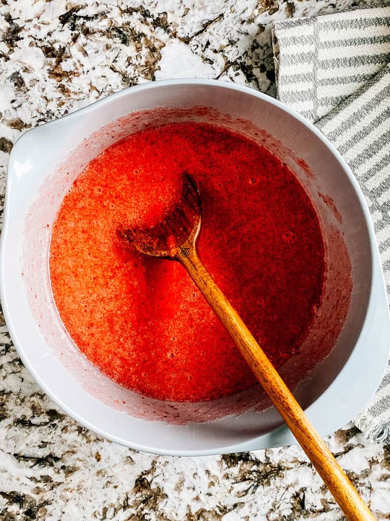 Blended strawberries and sugar mixed in a large bowl.