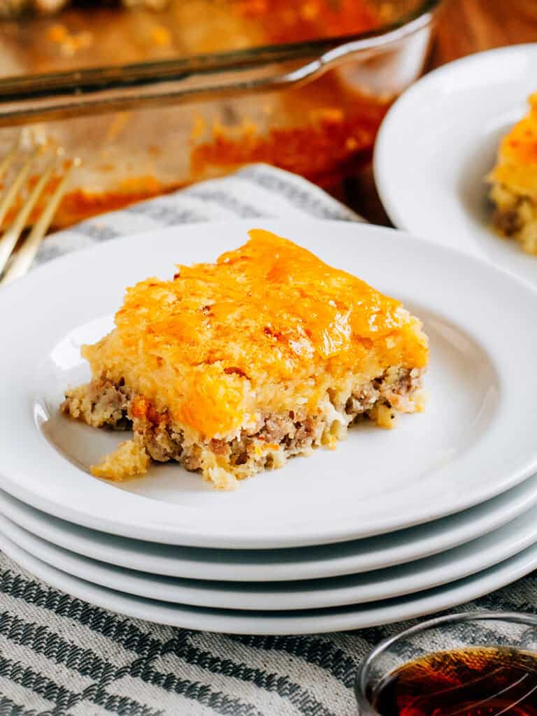 A savory and sweet slice of this yummy McGriddle inspired breakfast where you can see the layers on sausage and pancake with melted cheese on top.