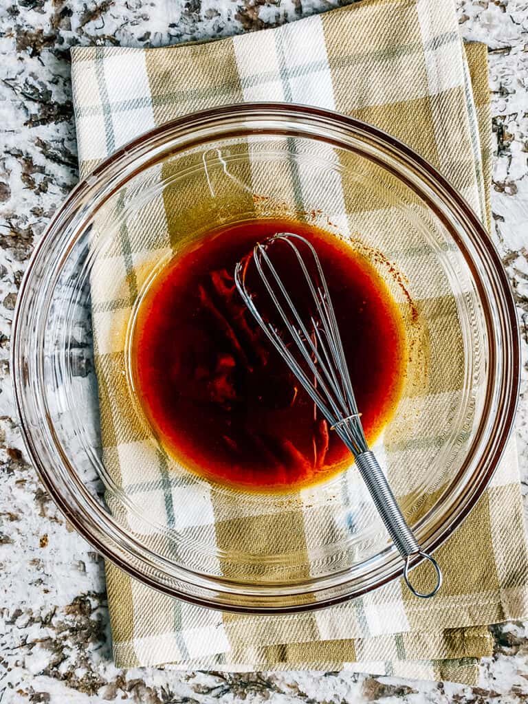 Whisked together cowboy caviar dressing at the bottom of a large bowl.