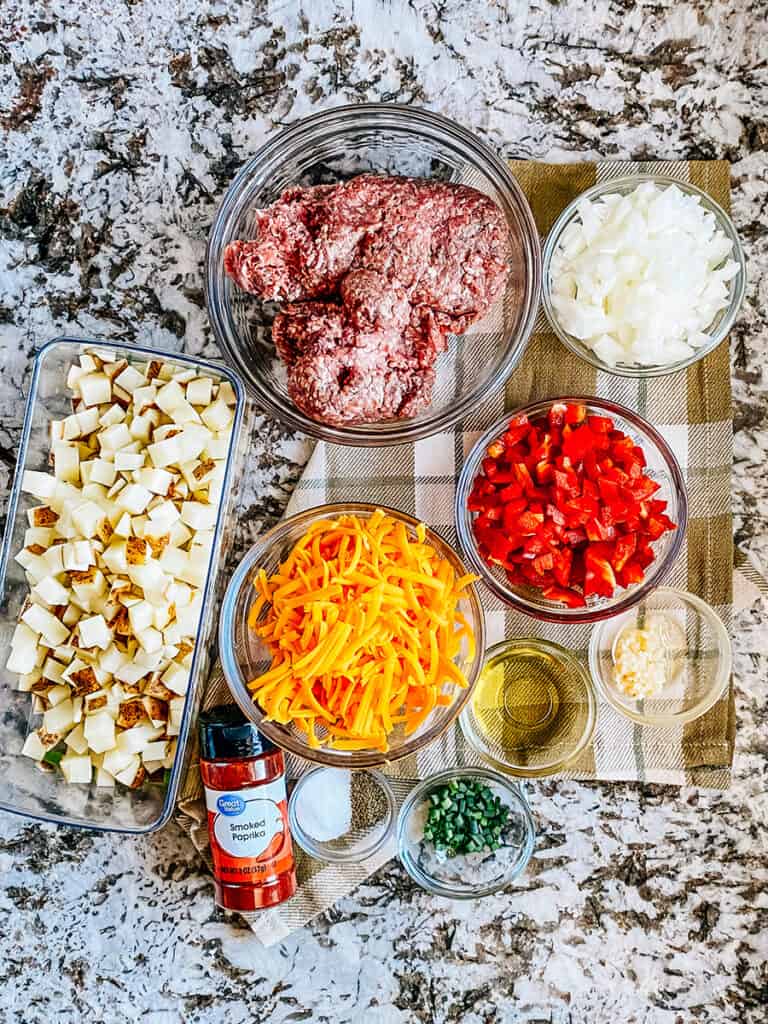 Ingredients to this Ground Beef and Potato Skillet recipe: one pound lean ground beef, diced potatoes, red bell pepper, sweet onion, shredded cheddar cheese, green onions, oil, garlic, smoked paprika, salt, and pepper.