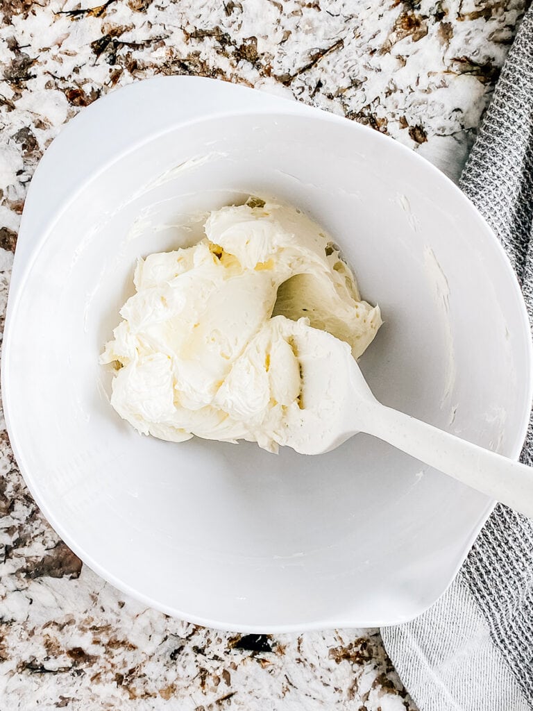 Creamed cream cheese in a large white mixing bowl