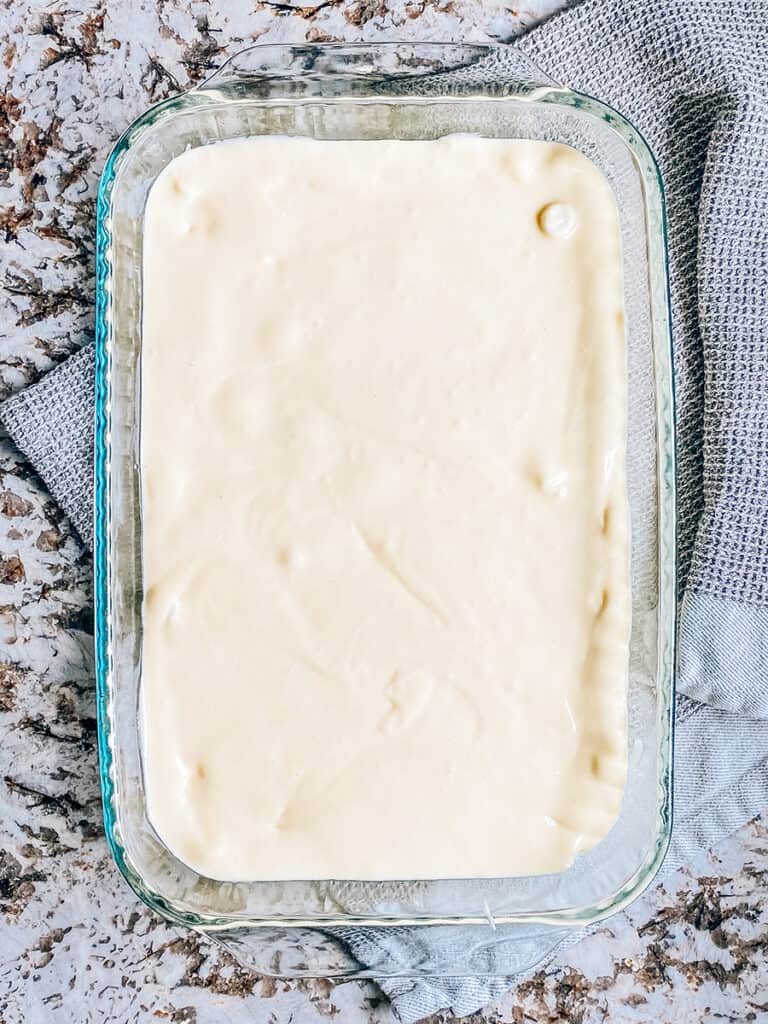 The white cake batter pour evenly in a layer on top of the mini marshmallows.