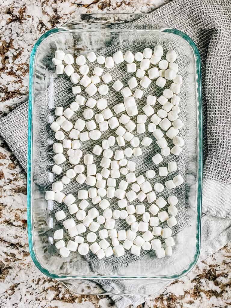 Mini marshmallows spread into an even layer in the baking dish.
