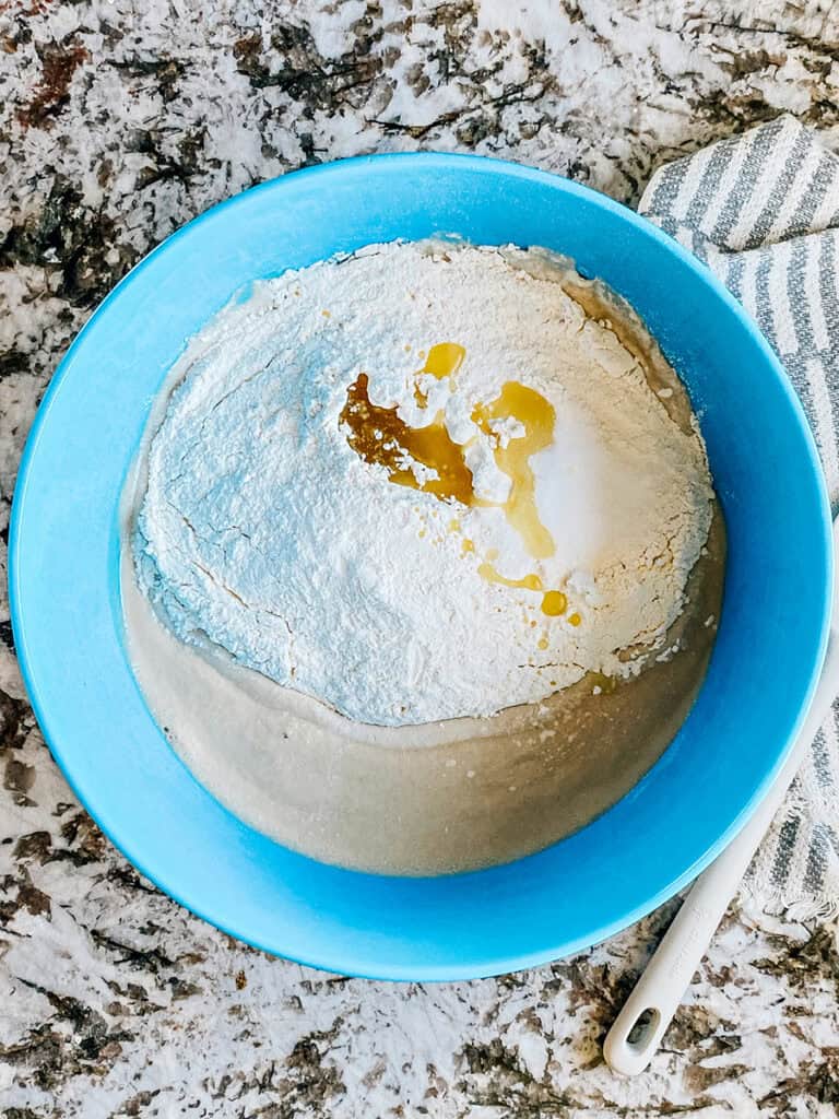 Flour, salt, and oil added to the proofed yeast.