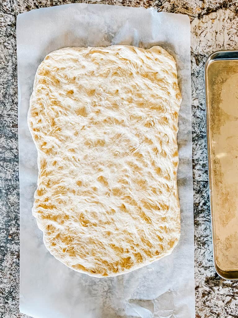 Pulled out dough to form the shape of the large rimmed baking sheet.