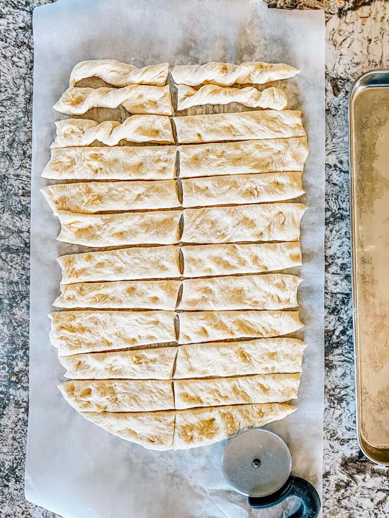 The dough sheet cut into long rectangles to make breadstick like shapes.
