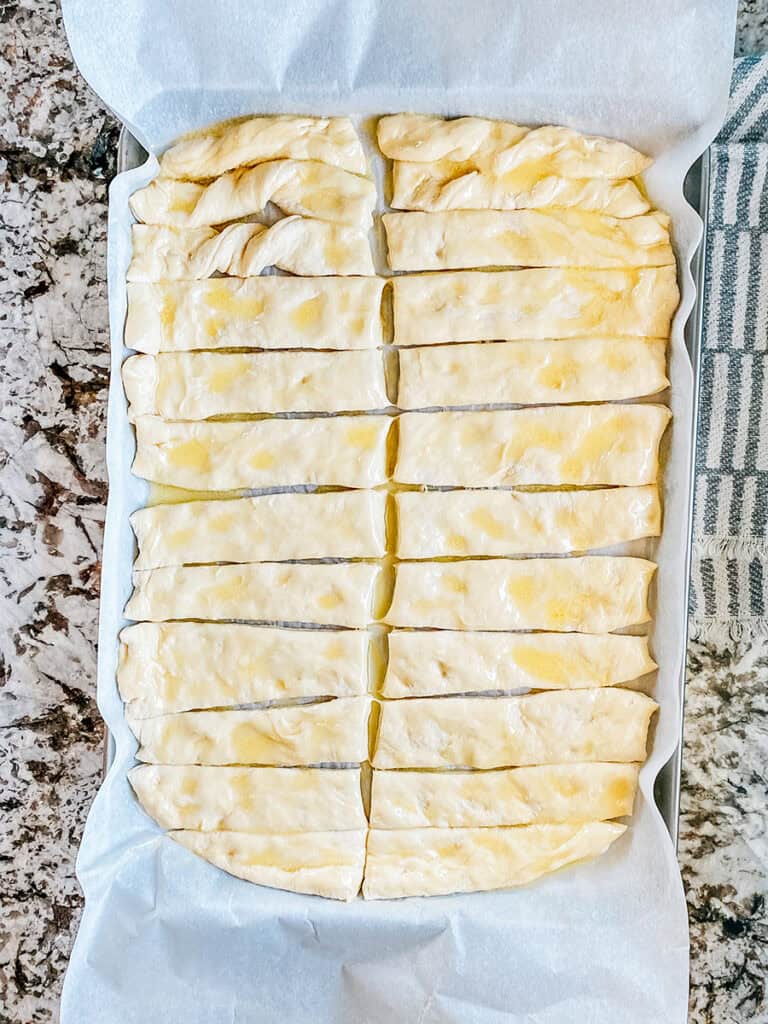 Melted butter brushed onto the breadstick dough.