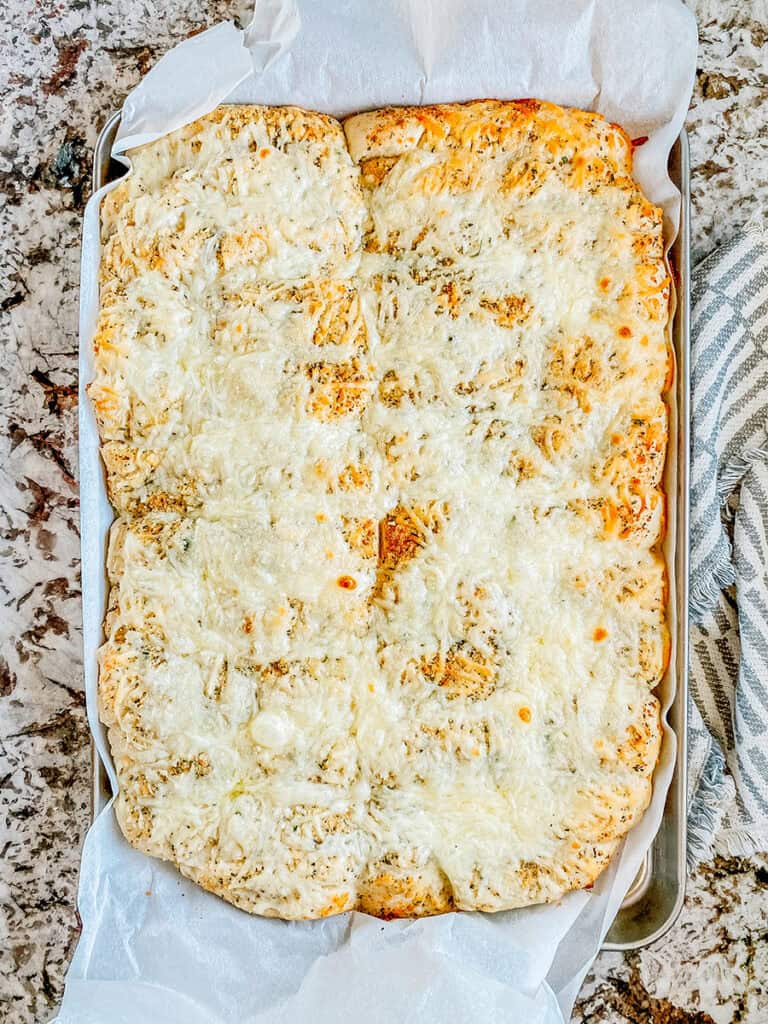 A whole sheet pan of fluffy golden brown breadsticks.