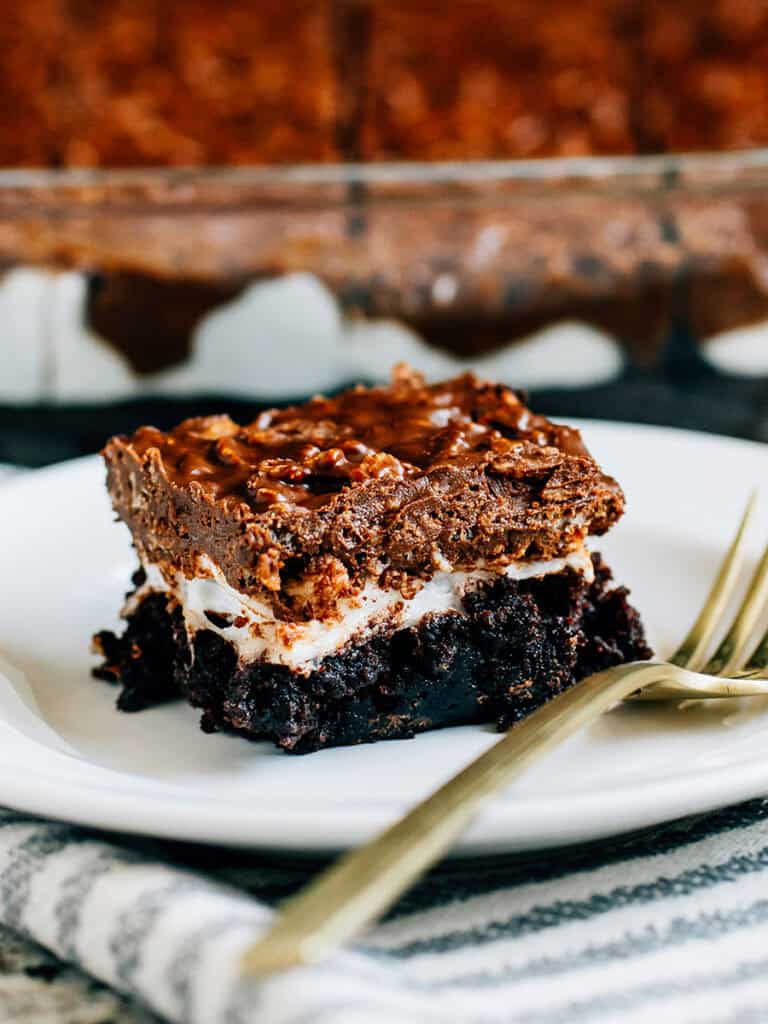 Plated loaded brownies with a layer of fudge brownies, melted marshmallows, and crispy chocolate and peanut butter topping.