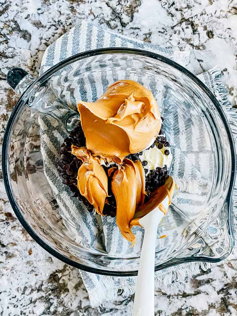 Butter, peanut butter, and chocolate chips in a glass mixing bowl.
