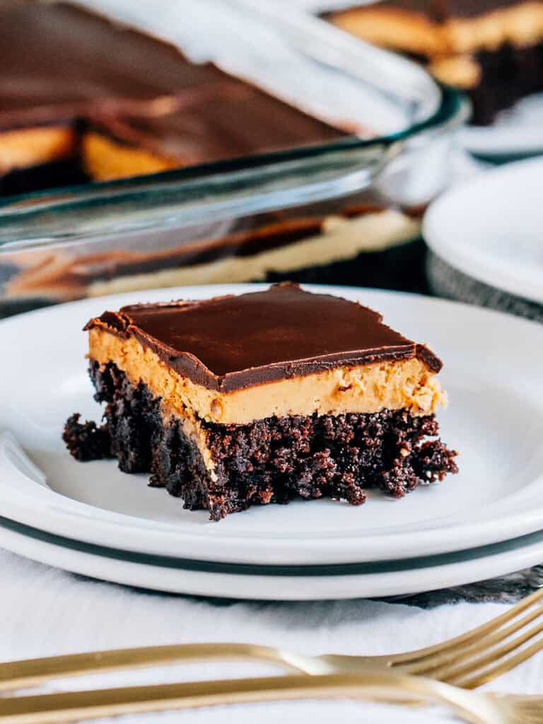 A completely cool and delicious buckey brownies with decadent layers of fudge brownie, peanut butter filling, and chocolate topping.