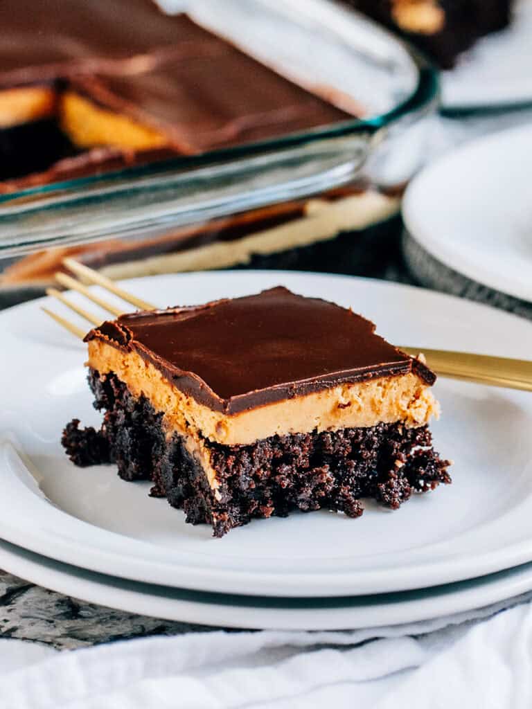 A buckeye brownie plated showing of the layers of brownie, peanut butter filling, and cool chocolate sauce topping.