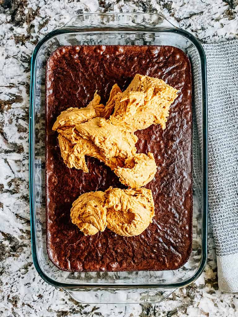 The peanut butter filling dolloped on top pf the baked brownies.