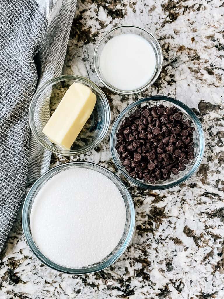 The ingredients to the one-minute chocolate frosting for zucchini brownies: butter, sugar, milk, semi-sweet chocolate chips.