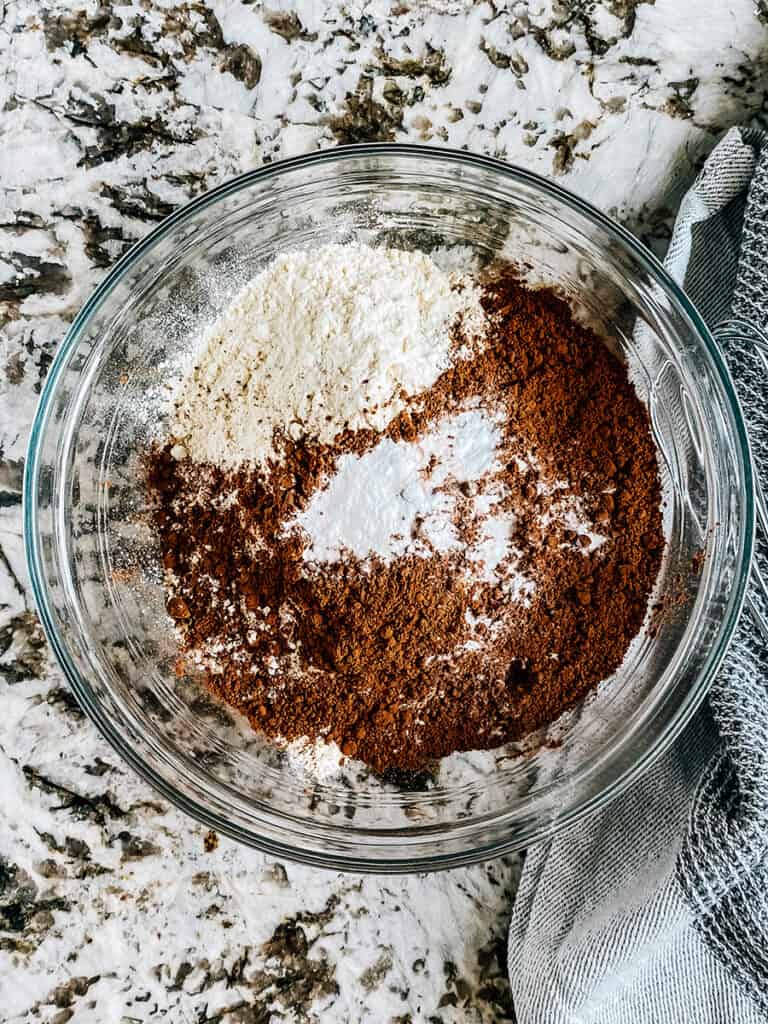 Flour, unsweetened cocoa powdered, and baking soda in a mixing bowl.