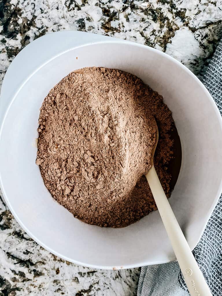 The dry ingredients on top of the wet ingredients in a large mixing bowl.